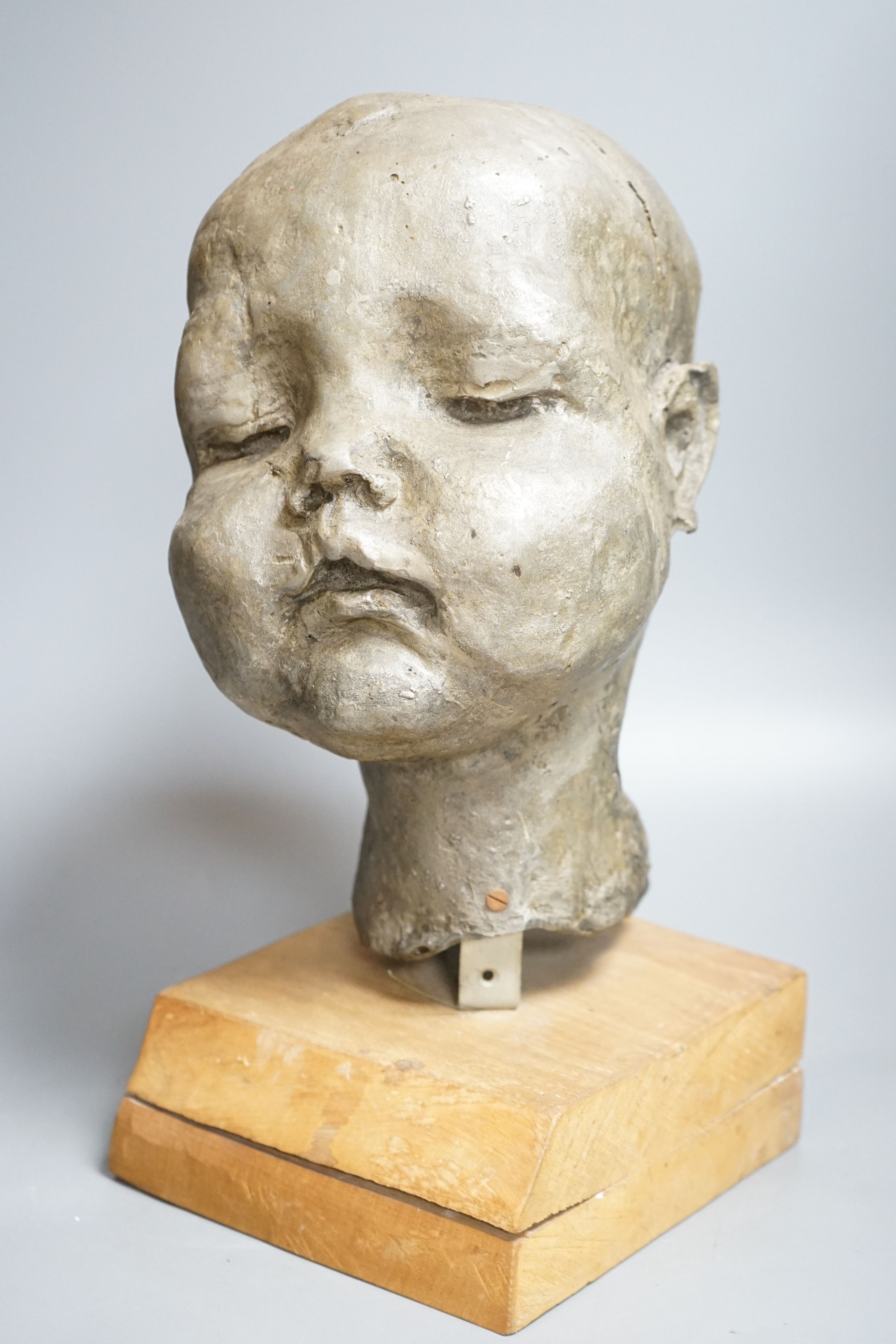 A composition sculpture of a child’s head 40 cm high including plinth